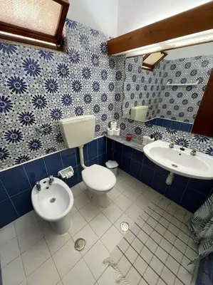 a blue and white bathroom with a toilet and a sink at Resort Albufeira T2, Praia da Oura in Albufeira