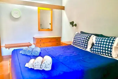 a bedroom with a blue bed with shoes on it at Resort Albufeira T2, Praia da Oura in Albufeira