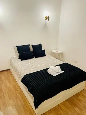 a bed with a black and white comforter and blue pillows at Apartament Two bedrooms Praia de Quarteira in Vilamoura