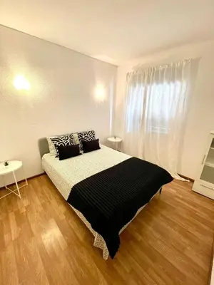 a bedroom with a black and white bed and a window at Apartament Two bedrooms Praia de Quarteira in Vilamoura