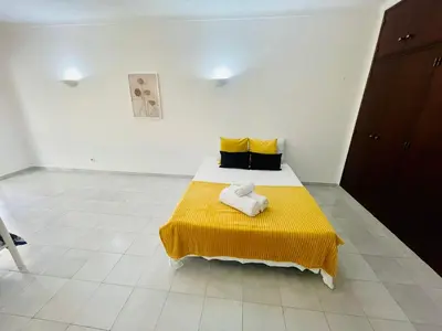 a bedroom with a bed with a yellow blanket at Amazing Studio Flat Albufeira in Albufeira