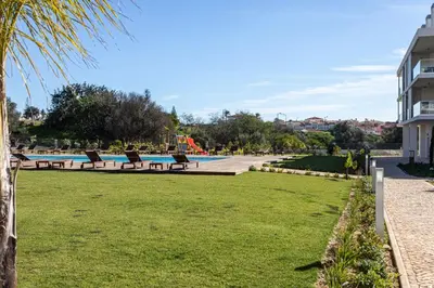 a park with benches and a swimming pool at The Albufeira Concierge - Prime Sunset Design in Albufeira