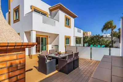 a house with a patio with a table and chairs at Villa Astro in Albufeira