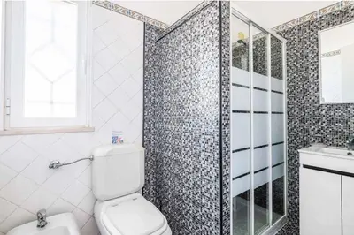 a bathroom with a toilet and a shower at Villa Ninos in Albufeira
