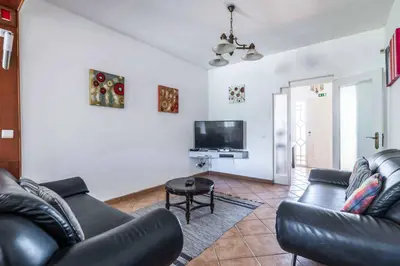 a living room with a black leather couch and a tv at Villa Ninos in Albufeira
