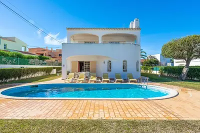 a villa with a swimming pool in front of a house at Villa Noras in Albufeira