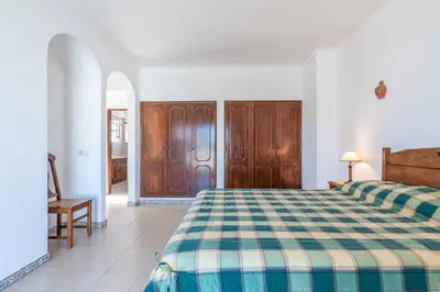 a bedroom with a bed with a checkered blanket at Villa Noras in Albufeira