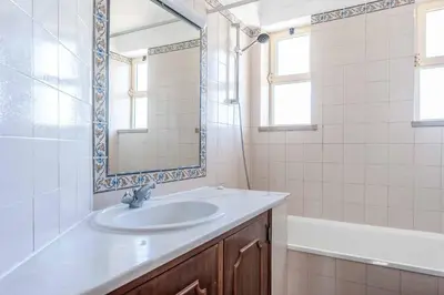 a bathroom with a sink and a mirror and a tub at Villa Noras in Albufeira