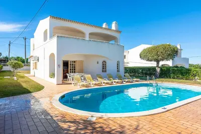 a villa with a swimming pool in front of a house at Villa Noras in Albufeira