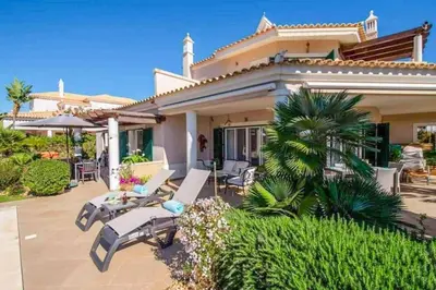 a bedroom with a bed and a table and a chair at Villa Sunset Golf in Vilamoura