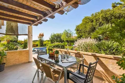 a bedroom with a large bed and a table at Villa Sunset Golf in Vilamoura