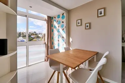 a dining room with a table and chairs and a window at Apartment Bay View Andrea mit Meerblick und Pool in Albufeira