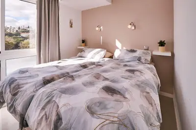 a bedroom with a bed with a comforter and a window at Apartment Bay View Andrea mit Meerblick und Pool in Albufeira