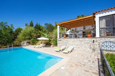 a villa with a swimming pool and a house at Villa Jacaranda Bordeira in Corotelo