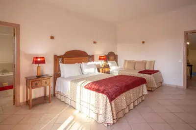 a hotel room with two beds and two lamps at Al Meida Guesthouse in Albufeira