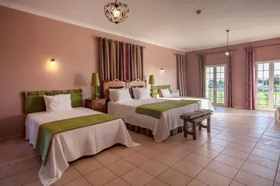 a hotel room with two beds and a chandelier at Al Meida Guesthouse in Albufeira