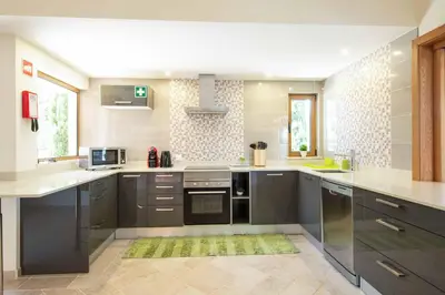 a large kitchen with black cabinets and white counter tops at Casa Salir in Salir