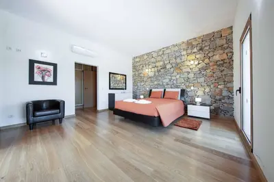 a bedroom with a bed and a stone wall at Casa Salir in Salir