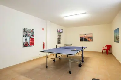 a ping pong table in a room with paintings at Casa Salir in Salir