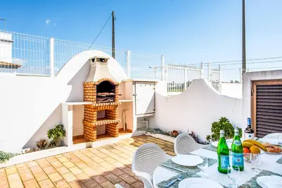 a patio with a pizza oven on top of a building at Villa Canto in Albufeira