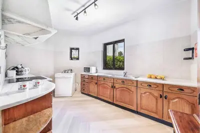 a kitchen with wooden cabinets and a white refrigerator at Villa Silveira II in Vilamoura