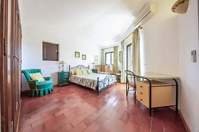 a bedroom with a bed and a chair and a table at Villa Silveira II in Vilamoura