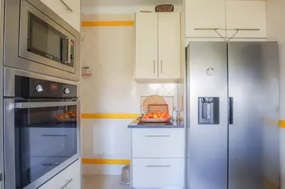 a kitchen with a refrigerator and a bowl of fruit at Villa Vale de Ursa - 16 - BY BEDZY in Sesmarias