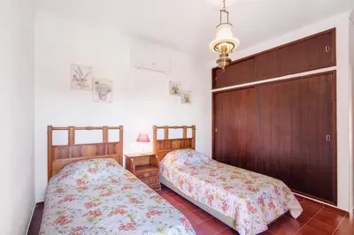 a bedroom with two beds and a wooden door at Villa Luísa Galé in Albufeira