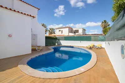 a villa with a swimming pool in front of a house at Villa Luísa Galé in Albufeira