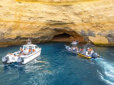 two boats in the water next to a cave at Apartment Rhodes by Algarve Vacation in Albufeira
