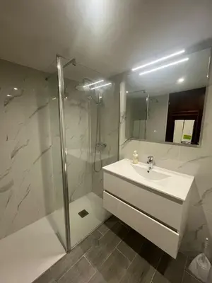 a white bathroom with a sink and a shower at TAC - Açoteias Budget Studio in Olhos de Água