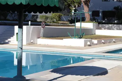 a swimming pool with a shadow on the water at TAC - Açoteias Budget Studio in Olhos de Água