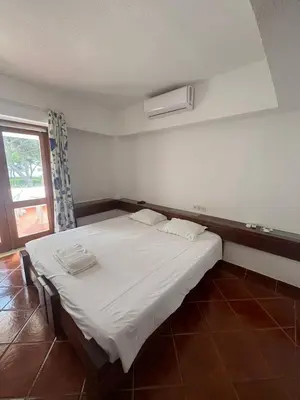 a bedroom with a large white bed with a window at TAC - Açoteias Budget Studio in Olhos de Água