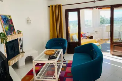 a living room with two blue chairs and a fireplace at Self-contained floor of Quinta / Villa in Guia