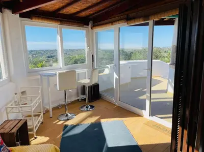 a room with large windows and a table and chairs at Self-contained floor of Quinta / Villa in Guia