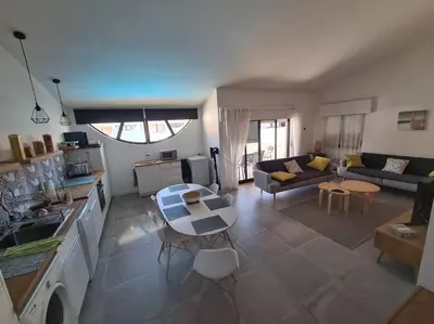 a kitchen and living room with a table and a couch at VILAMOURA APARTMENT NEAR MARINA AND BEACHES in Quarteira