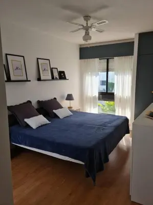 a bedroom with a blue bed and a window at VILAMOURA APARTMENT NEAR MARINA AND BEACHES in Quarteira