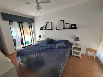a bedroom with a bed with a blue comforter at VILAMOURA APARTMENT NEAR MARINA AND BEACHES in Quarteira