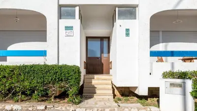 a white house with a brown door and stairs at Comfy 2 BDR Apartment W/ Balcony by LovelyStay in Albufeira