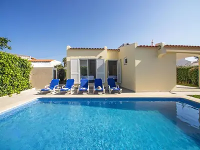 a swimming pool with blue chairs and a house at Holiday Home LY - VIP Properties by Interhome in Albufeira