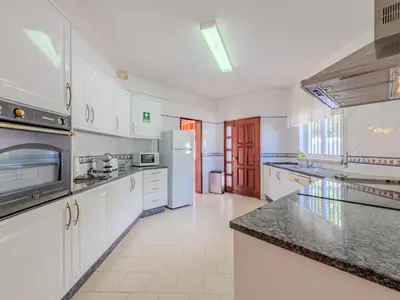 a kitchen with white cabinets and a stove top oven at Holiday Home Paulo - VIP Properties by Interhome in Galé
