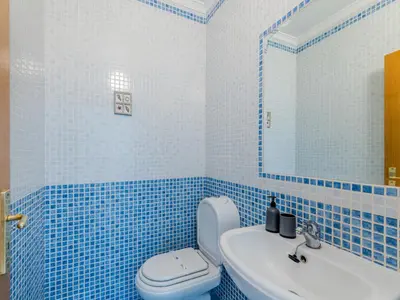 a blue tiled bathroom with a toilet and a sink at Holiday Home Camélias VIP Properties by Interhome in Albufeira