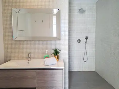 a bathroom with a sink and a shower with a mirror at Holiday Home Lima - VIP Properties by Interhome in Albufeira