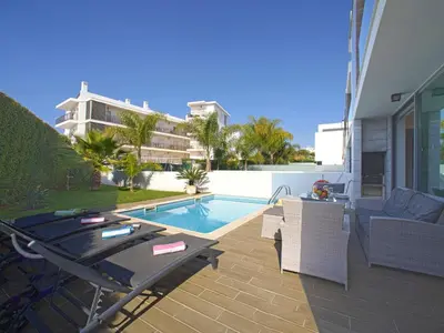 a patio with a table and chairs next to a pool at Villa Pires - VIP Properties by Interhome in Albufeira