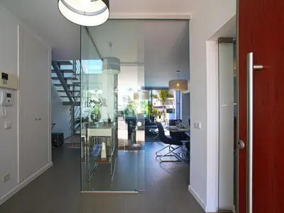a hallway with glass walls and a table and chairs at Villa Pires - VIP Properties by Interhome in Albufeira