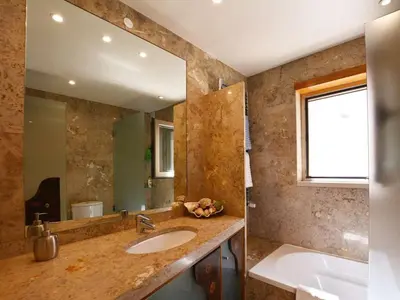 a bathroom with a sink and a tub and a mirror at Special Vilamoura Villa 6 Bedrooms Villa Lagoon Private Pool in Quarteira
