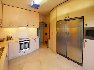 a kitchen with white cabinets and stainless steel appliances at Special Vilamoura Villa 6 Bedrooms Villa Lagoon Private Pool in Quarteira