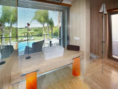 a bathroom with a tub and a sink and a pool at Special Vilamoura Villa 6 Bedrooms Villa Lagoon Private Pool in Quarteira