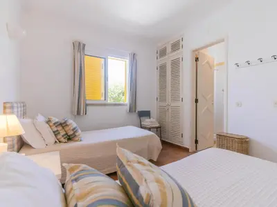 a small bedroom with two beds and a window at AL - Aldeia do Golfe Retreat in Vilamoura