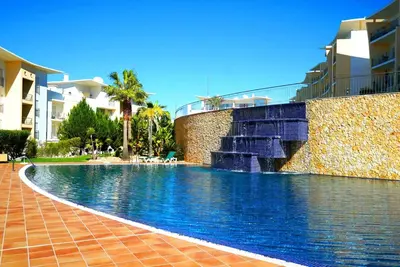 a swimming pool with a water fountain next to a building at AlbufeiraOrada Cozy&Sunny Condo by BeCherish in Albufeira